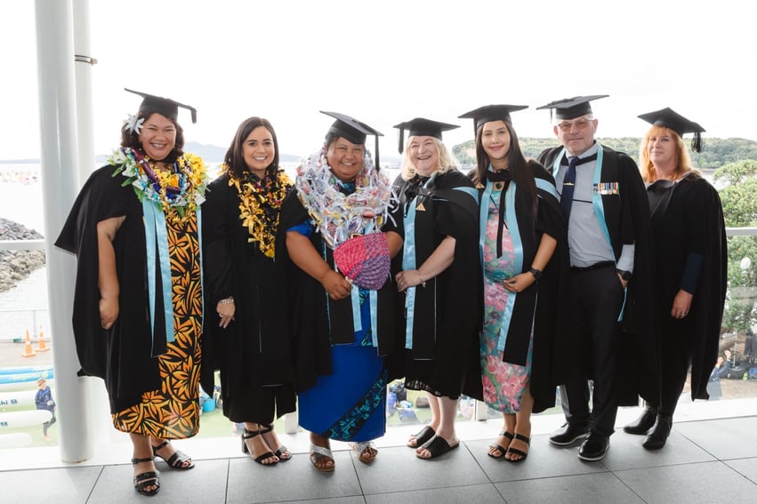 Graduates standing on balcony overlooking the ocean