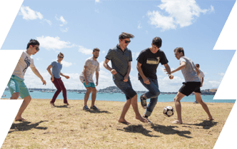 Group of men playing football near the beach