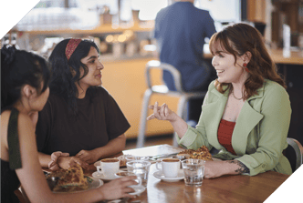 Diverse group of young woman talking in a cafe