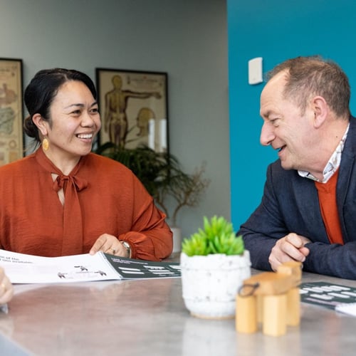 Woman and man smiling and discussing documents